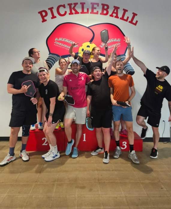 A group of people on a podium at the Pickleball Food Pub after playing in a league