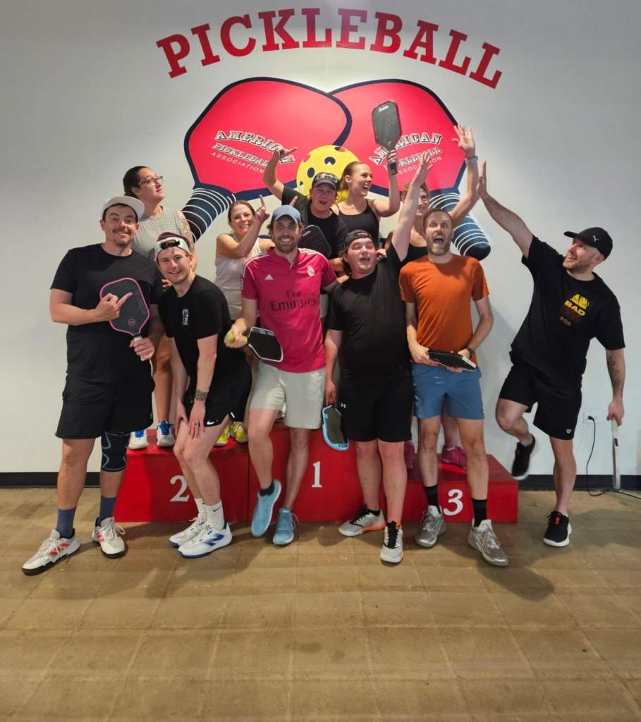 A group of people on a podium at the Pickleball Food Pub after playing in a league